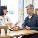 Ein Mann ist beim Kardiologen und wird umfassend beraten.