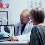 Eine ältere Frau ist beim Kardiologen und er erklärt ihr die Ergebnisse.